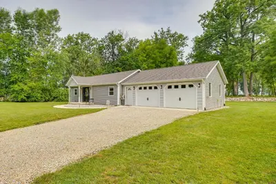 a house with two garage doors and a gravel driveway at Grand Lake Getaway with Boat Dock in St Marys!