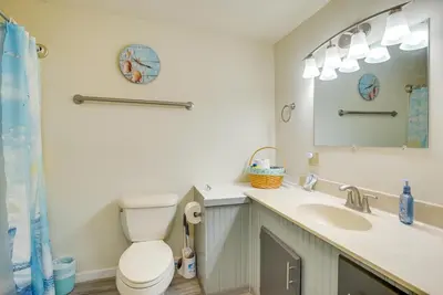 a bathroom with a toilet and a sink and a mirror at Grand Lake Getaway with Boat Dock in St Marys!
