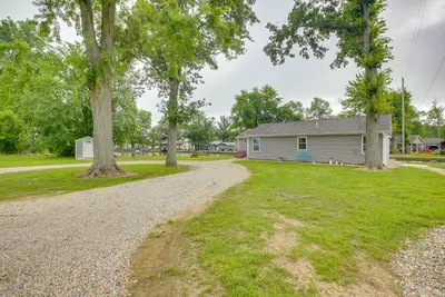 a gravel road in front of a house with trees at Grand Lake Cabin with Private Dock in St Marys!