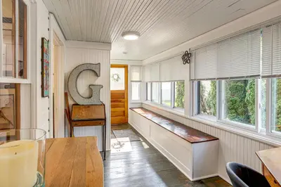 a hallway with windows and a bench in a room at Walk to Private Beach Lake Erie Retreat with Yard! in Huron