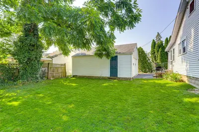 a yard with a house and a fence at Walk to Private Beach Lake Erie Retreat with Yard! in Huron