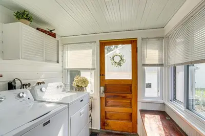a kitchen with white appliances and a wooden door at Walk to Private Beach Lake Erie Retreat with Yard! in Huron