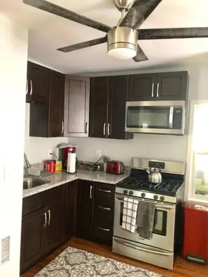 a kitchen with a stove and a microwave at The House Hotels - W45th Backhouse - Ohio City in Cleveland