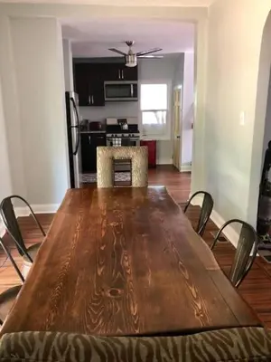 a wooden table and chairs in a living room at The House Hotels - W45th Backhouse - Ohio City in Cleveland