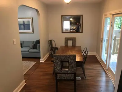 a dining room with a table and chairs and a couch at The House Hotels - W45th Backhouse - Ohio City in Cleveland