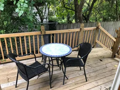 a patio table and chairs on a wooden deck at The House Hotels - W45th Backhouse - Ohio City in Cleveland