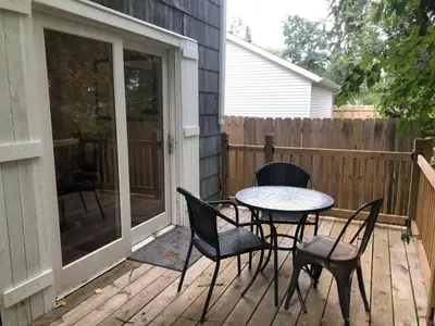 a patio with a table and chairs on a deck at The House Hotels - W45th Backhouse - Ohio City in Cleveland