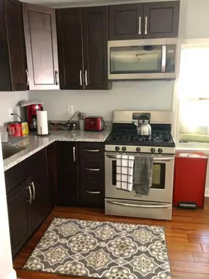 a kitchen with a stove and a rug on the floor at The House Hotels - W45th Backhouse - Ohio City in Cleveland
