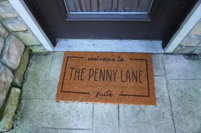 a welcome to the penny lane club sign in front of a door at The Penny Lane Suite in Akron