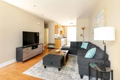a living room with a couch and a flat screen tv at The Penny Lane Suite in Akron