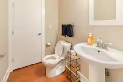 a bathroom with a white toilet and a sink at The Penny Lane Suite in Akron
