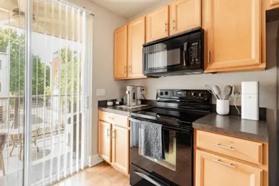 a kitchen with a stove and a microwave at The Penny Lane Suite in Akron