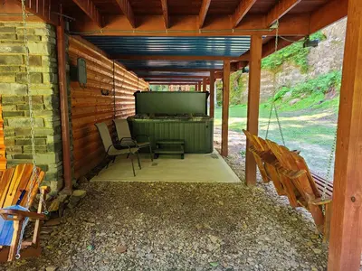 a screened in porch with a television and chairs at A Birds Eye View Cabin Rentals in Logan