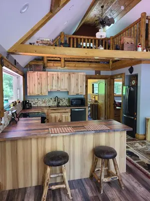 a kitchen with a counter and two stools at A Birds Eye View Cabin Rentals in Logan