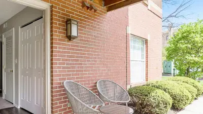 two wicker chairs sitting next to a brick building at Landing Chic 1BD Clubhouse Gym in Dayton