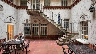 a woman sitting at a table in front of a building at Landing Chic 1BD Clubhouse Gym in Dayton