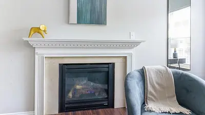 a living room with a fireplace and a blue chair at Landing Chic 1BD Clubhouse Gym in Dayton