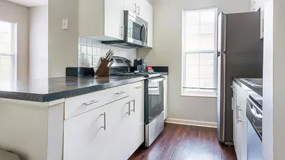 a kitchen with white cabinets and a black counter top at Landing Chic 1BD Clubhouse Gym in Dayton