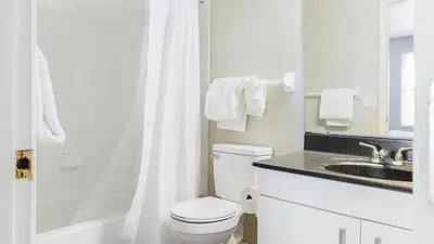 a white bathroom with a toilet and a sink at Landing Chic 1BD Clubhouse Gym in Dayton