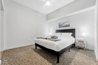 a white bedroom with a large bed in a room at Spacious DT Condo l Free Parking l Fast Wi-Fi in Cleveland
