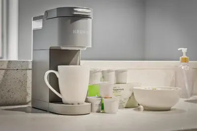 a coffee maker and cups sitting on a counter at Spacious DT Condo l Free Parking l Fast Wi-Fi in Cleveland