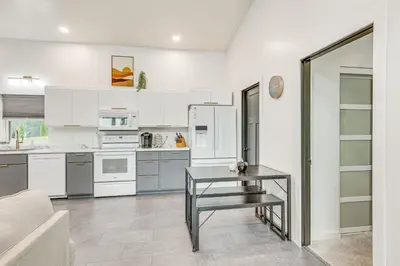 a kitchen with white cabinets and a table at 4 Mi to Mohican River Ohio Amish Country Cottage in Walhonding