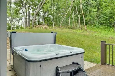 a hot tub on a deck with a chair at 4 Mi to Mohican River Ohio Amish Country Cottage in Walhonding