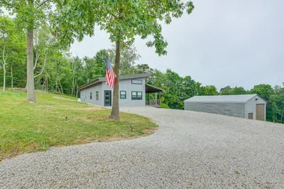 a house with a flag on the side of a driveway at 4 Mi to Mohican River Ohio Amish Country Cottage in Walhonding