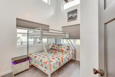 a bedroom with a bunk bed in a room with windows at 4 Mi to Mohican River Ohio Amish Country Cottage in Walhonding