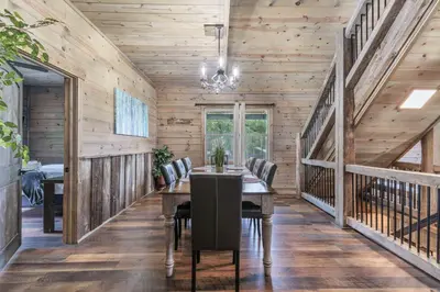 a dining room with wooden walls and a table and chairs at Serenity Ridge 6 Br Sleeps 16 Pool Hot Tub in Creola