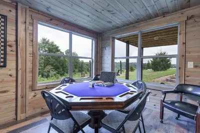 a dining room with a table with a laptop on it at Serenity Ridge 6 Br Sleeps 16 Pool Hot Tub in Creola
