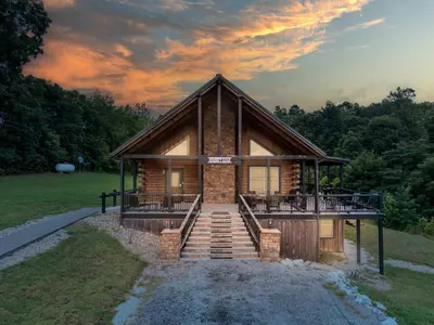 a log cabin with a deck and stairs in front at Serenity Ridge 6 Br Sleeps 16 Pool Hot Tub in Creola