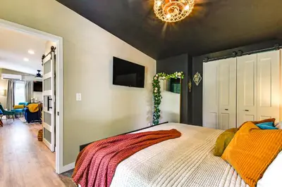 a bedroom with a large bed and a chandelier at BBQ Ready Retreat on Rice Near Licking River