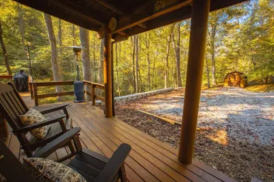 a porch of a cabin with chairs and a forest at Diamond Creek | Sleeps up to 6 in Gallipolis