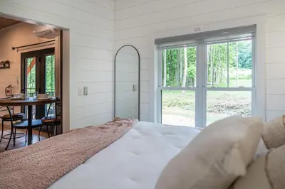 a bedroom with a bed and a table and a window at Luxe Studio in Millersburg