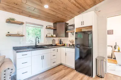 a kitchen with white cabinets and a stainless steel refrigerator at Luxe Studio in Millersburg
