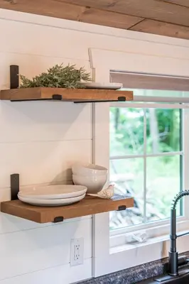 a kitchen counter with plates and bowls on a shelf at Luxe Studio in Millersburg