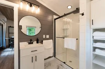 a bathroom with a shower and a sink and a mirror at Luxe Studio in Millersburg