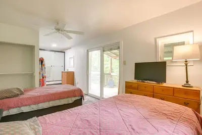 a bedroom with two beds and a flat screen tv at 1 Mi to Burr Oak Lake Cozy Family Home! in Corning