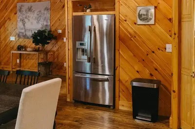 a stainless steel refrigerator in a room with wooden walls at 