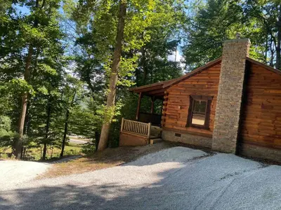 a wooden cabin with a bench in the woods at 
