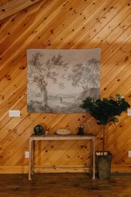a painting hanging on a wall with a wooden ceiling at 