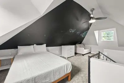 a bedroom with a bed and a black wall at The Southern Nook - For 8 in Columbus