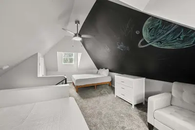 a bedroom with a black wall with a planet mural at The Southern Nook - For 8 in Columbus