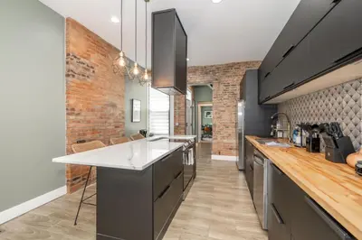 a kitchen with a counter and a brick wall at The Baymiller Row - For 6 in Cincinnati