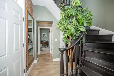 a hallway with a staircase with a potted plant at The Baymiller Row - For 6 in Cincinnati