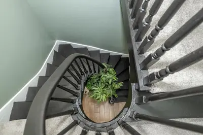 a spiral staircase with a plant in the middle at The Baymiller Row - For 6 in Cincinnati