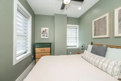 a bedroom with a bed and two windows at The Baymiller Row - For 6 in Cincinnati