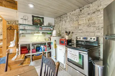 a kitchen with a stove and a stone wall at 3 Mi to River 11-Acre Retreat in Rural Stockport in Chesterhill