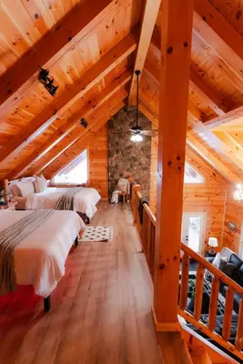 a room with two beds in a log cabin at Sleeps 16 Luxury Cabin with Game Room & Hot Tub in Logan